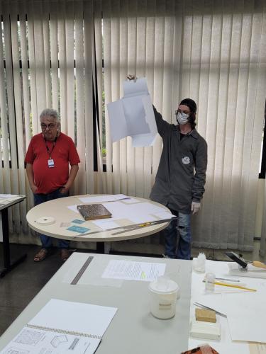 Colaborador Willian Henrique Odreski do SPD-Seção de Preservação de Documentos, demonstrando o processo de acondicionamento dos arquivos.