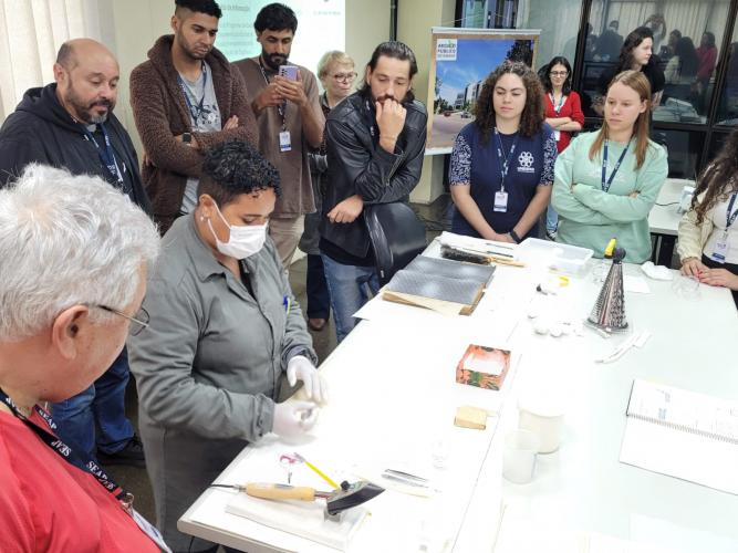 Colaboradora Sabrina Maria da Silva apresentando os trabalhos realizados no setor de Preservação de Documentos