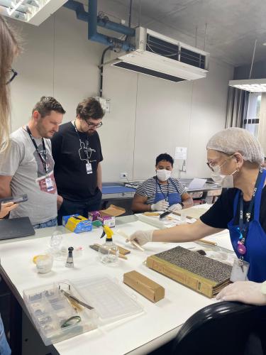 Ana Paula Joukoski e Sabrina Maria da Silva, da Seção de Preservação de Documentos, demonstram os diversos procedimentos técnicos de higienização, reparo, acondicionamento e arrolamento pelos quais passam os documentos do Arquivo Público do Paraná.