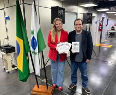 Kássia Cavalari Basso, Diretora do Arquivo Público, recebe exemplares do novo livro de André Luiz Molina.