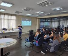 A colaboradora Ana Paula, da Seção de Preservação de Documentos (SPD), explica o processo detalhado de limpeza e higienização dos documentos, destacando as etapas e os cuidados necessários para preservar a integridade dos acervos históricos e administrativos.