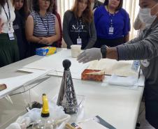 A colaboradora Sabrina Maria da Silva, da Seção de Preservação de Documentos (SPD), apresenta os trabalhos desenvolvidos em seu setor, detalhando as técnicas de conservação e restauração aplicadas para garantir a integridade e a longevidade dos documentos históricos.