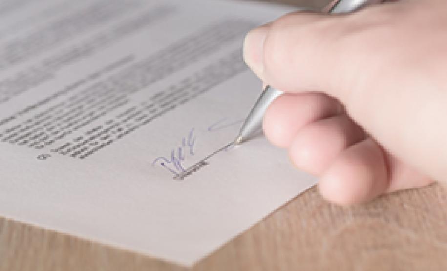 Pessoa assinando documento