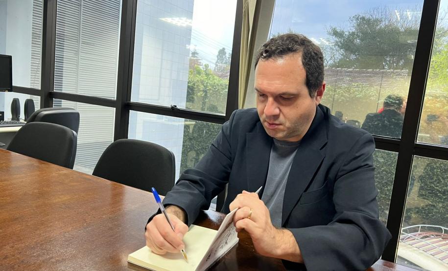 André Luiz Molina presenteia o Arquivo Público do Paraná com seu livro especialmente autografado.