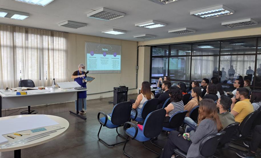 A colaboradora Ana Paula, da Seção de Preservação de Documentos (SPD), explica o processo detalhado de limpeza e higienização dos documentos, destacando as etapas e os cuidados necessários para preservar a integridade dos acervos históricos e administrativos.