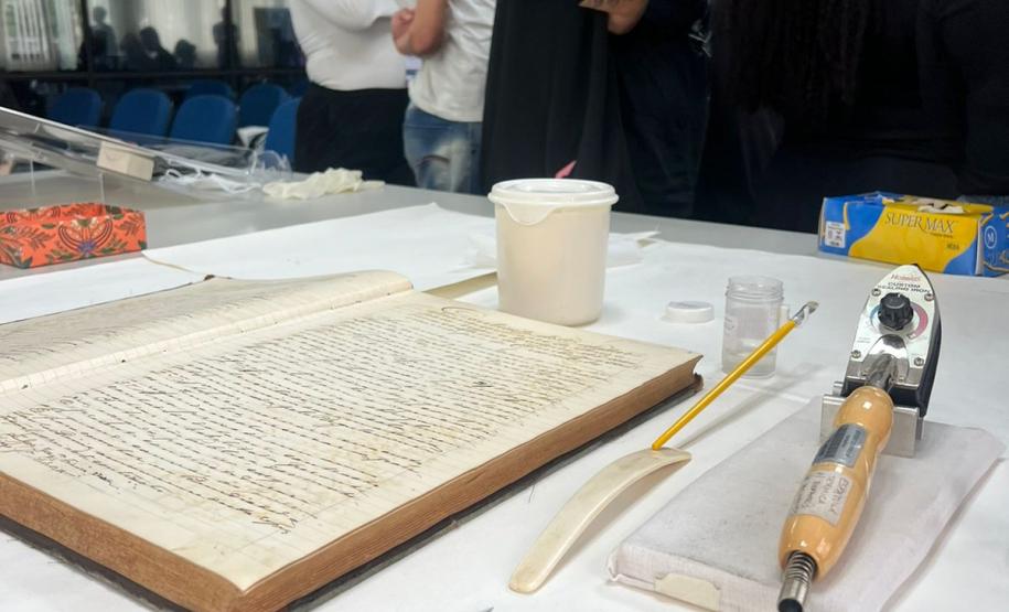 Durante a visita, os alunos e professores tiveram a oportunidade de conhecer as ferramentas e técnicas utilizadas no setor de Preservação de Documentos (SPD). A equipe do setor apresentou detalhadamente os equipamentos e materiais empregados na conservação e restauração de documentos