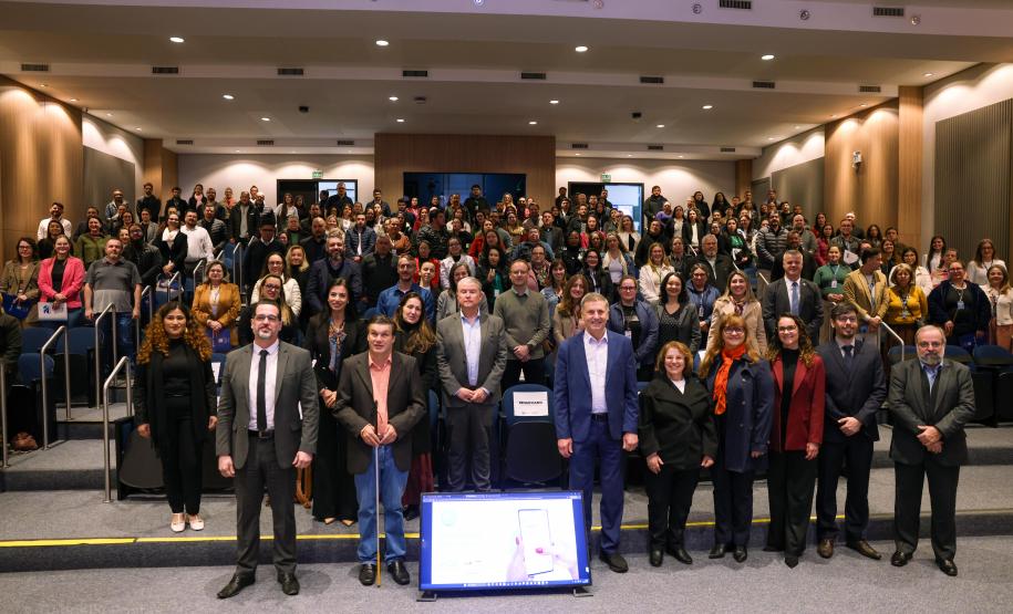 Participantes do lançamento do eProtocolo olham para a câmera e sorriem.